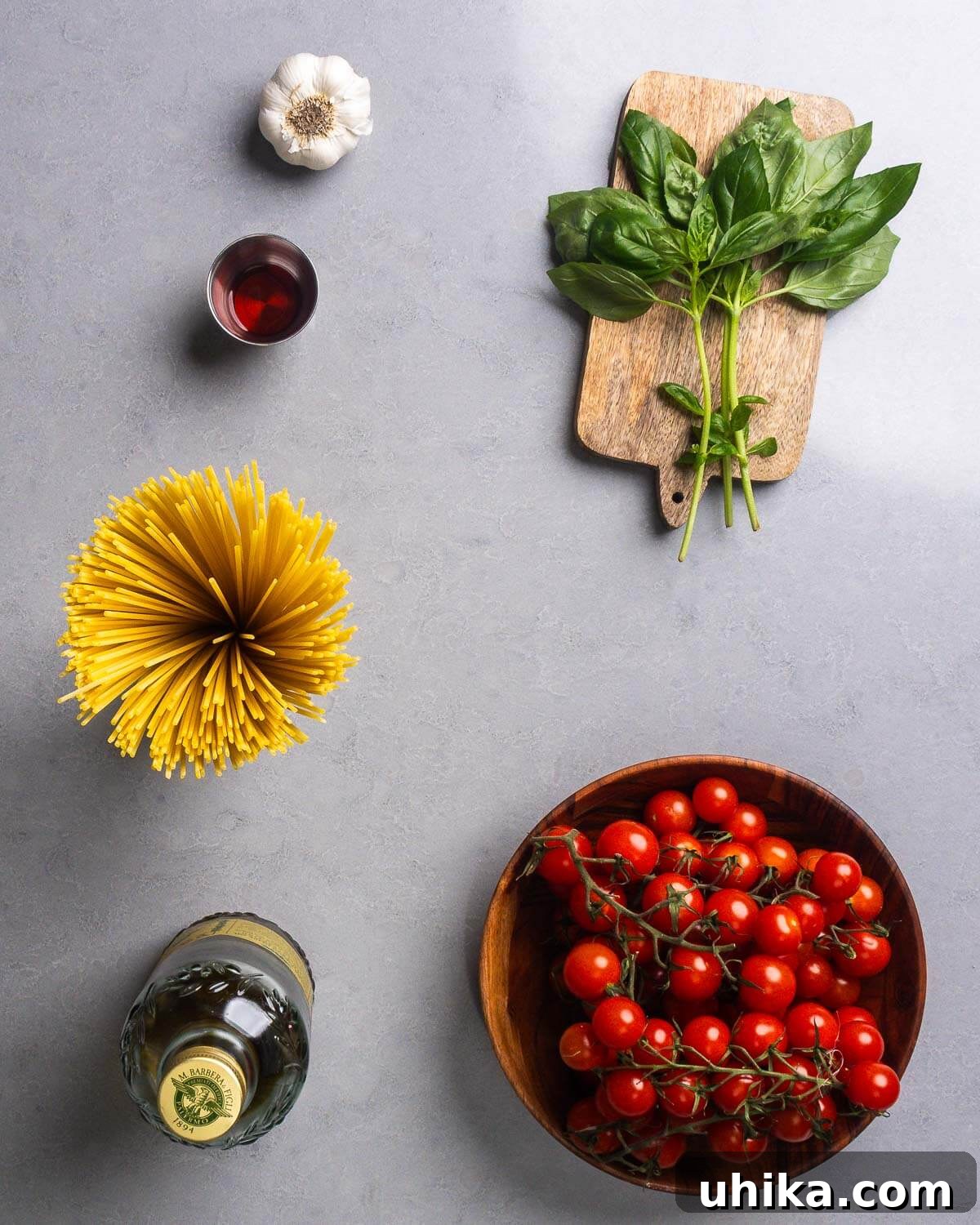 Fresh No-Cook Tomato Sauce Recipe — Perfect Summer Pasta Topping 4 Ingredients shown: garlic, red wine vinegar, basil, pasta, olive oil, and cherry tomatoes.
