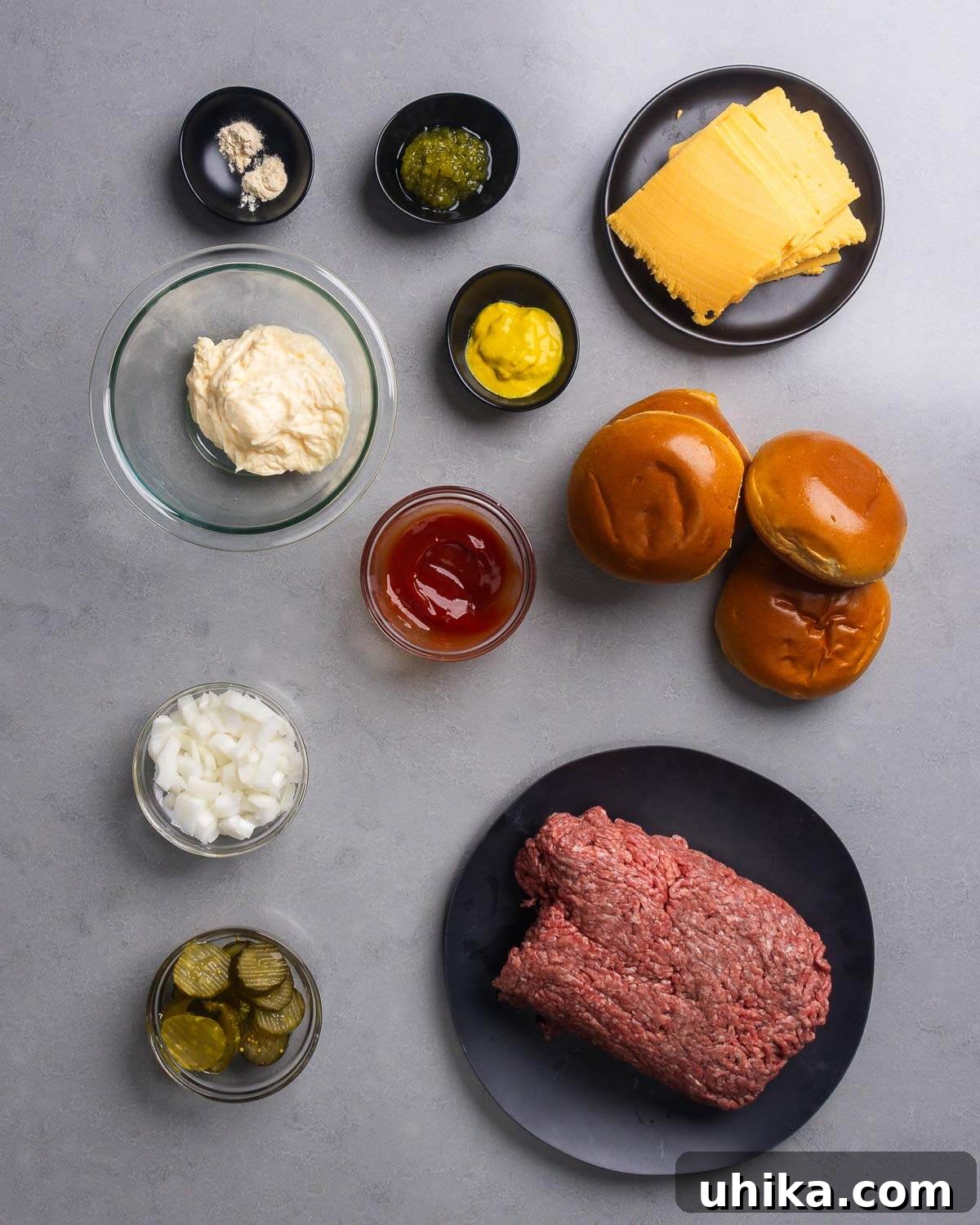 Crispy Smash Burgers with Zesty Signature Sauce 4 Ingredients shown: garlic and onion powder, relish, mustard, American cheese, mayonnaise, ketchup, brioche buns, diced onion, pickle chips, and ground chuck.