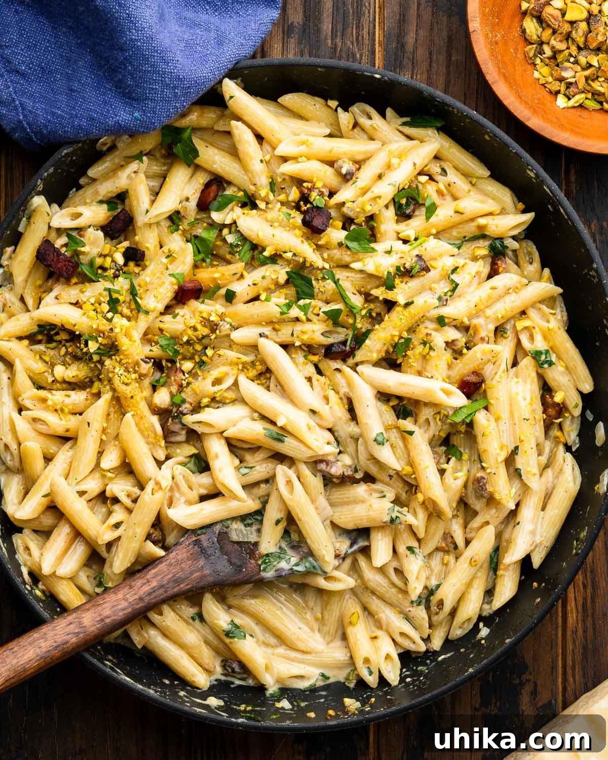 Pistachio Pesto Pasta with Lemon and Parmesan 2 Pan with pistachio pasta and bowl of chopped pistachios on the side.