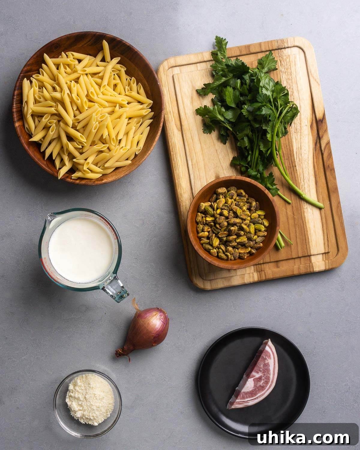 Pistachio Pesto Pasta with Lemon and Parmesan 4 Ingredients shown: penne pasta, pistachios, parsley, heavy cream, shallot, parmesan cheese, and pancetta.