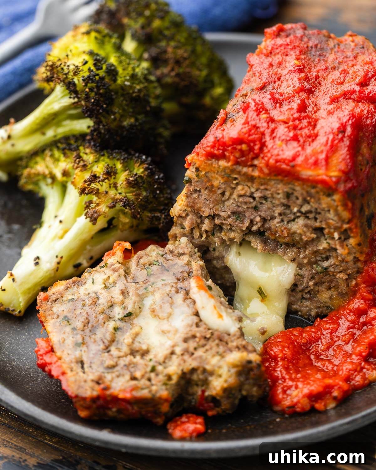 Mini Italian-Style Stuffed Meatloaves 2 Mini stuffed meatloaf on plate with roasted broccoli.