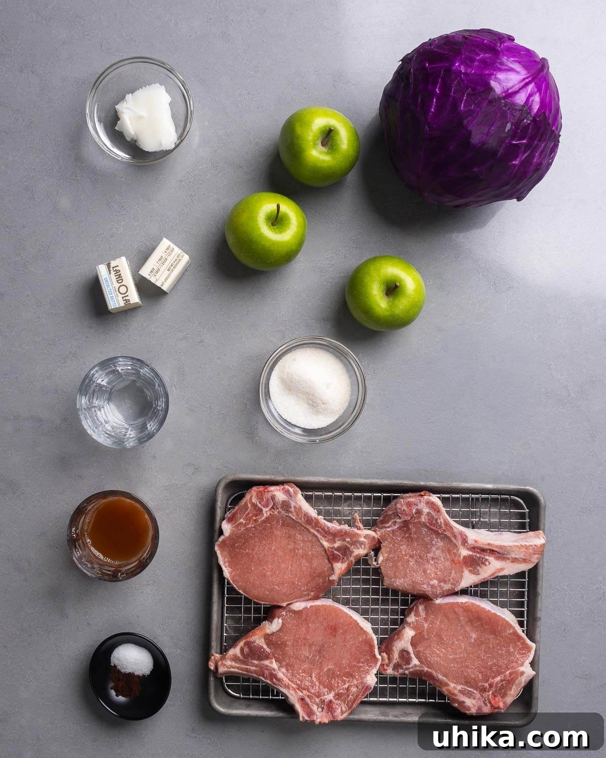 Pan-Seared Pork Chops with Braised Cabbage for Fall 4 Ingredients shown: lard, apples, cabbage, butter, water, sugar, cider vinegar, salt, cloves, and pork chops.