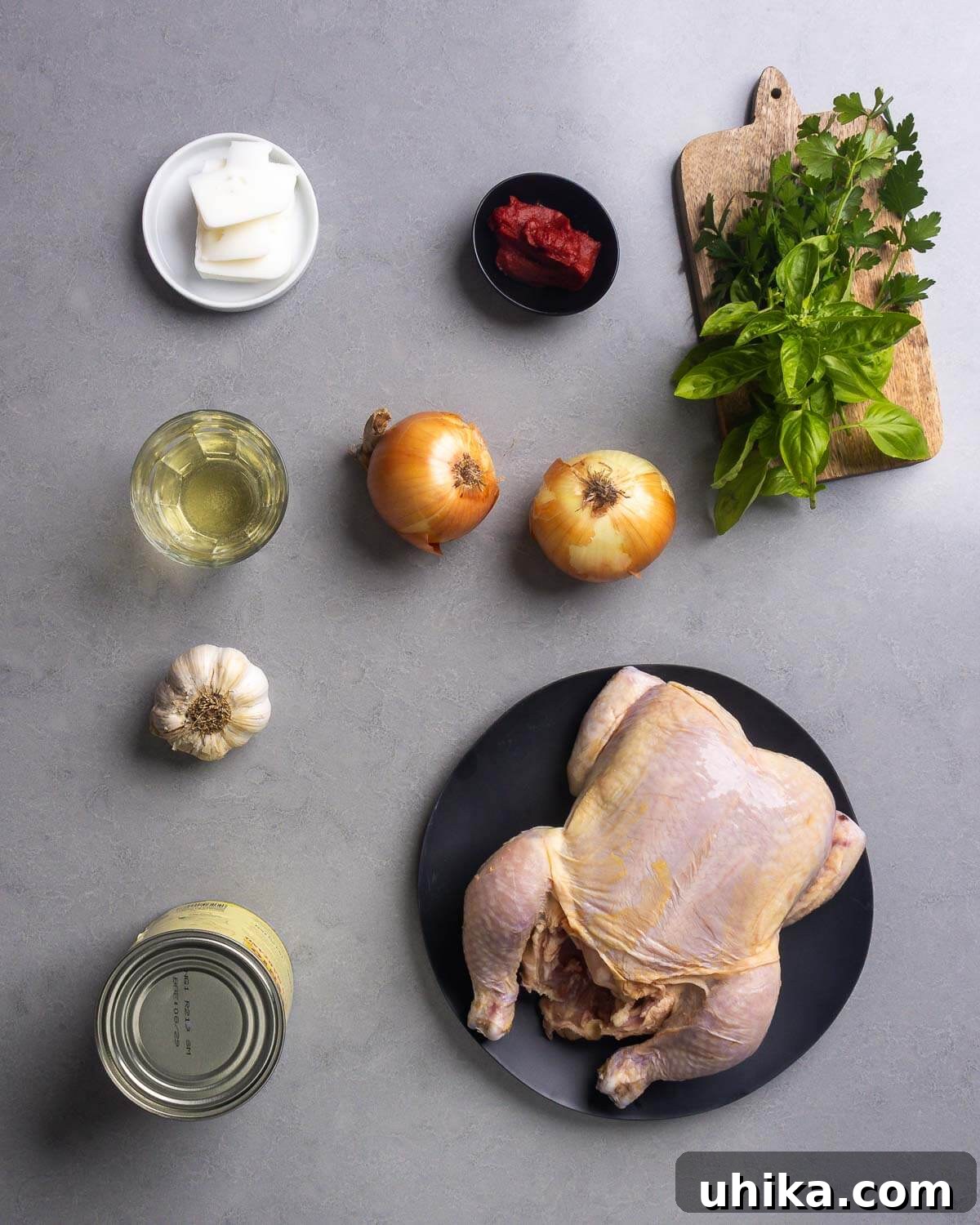 Pollo alla Potentina: Spicy Italian Braised Chicken with Tomatoes 4 Ingredients shown: lard, tomato paste, basil, parsley, white wine, onions, garlic, plum tomatoes, and a whole chicken.