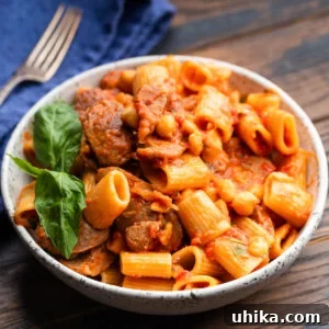 One-Pot Sausage and Chickpea Pasta 7 Large bowl with sausage chickpea pasta garnished with basil.