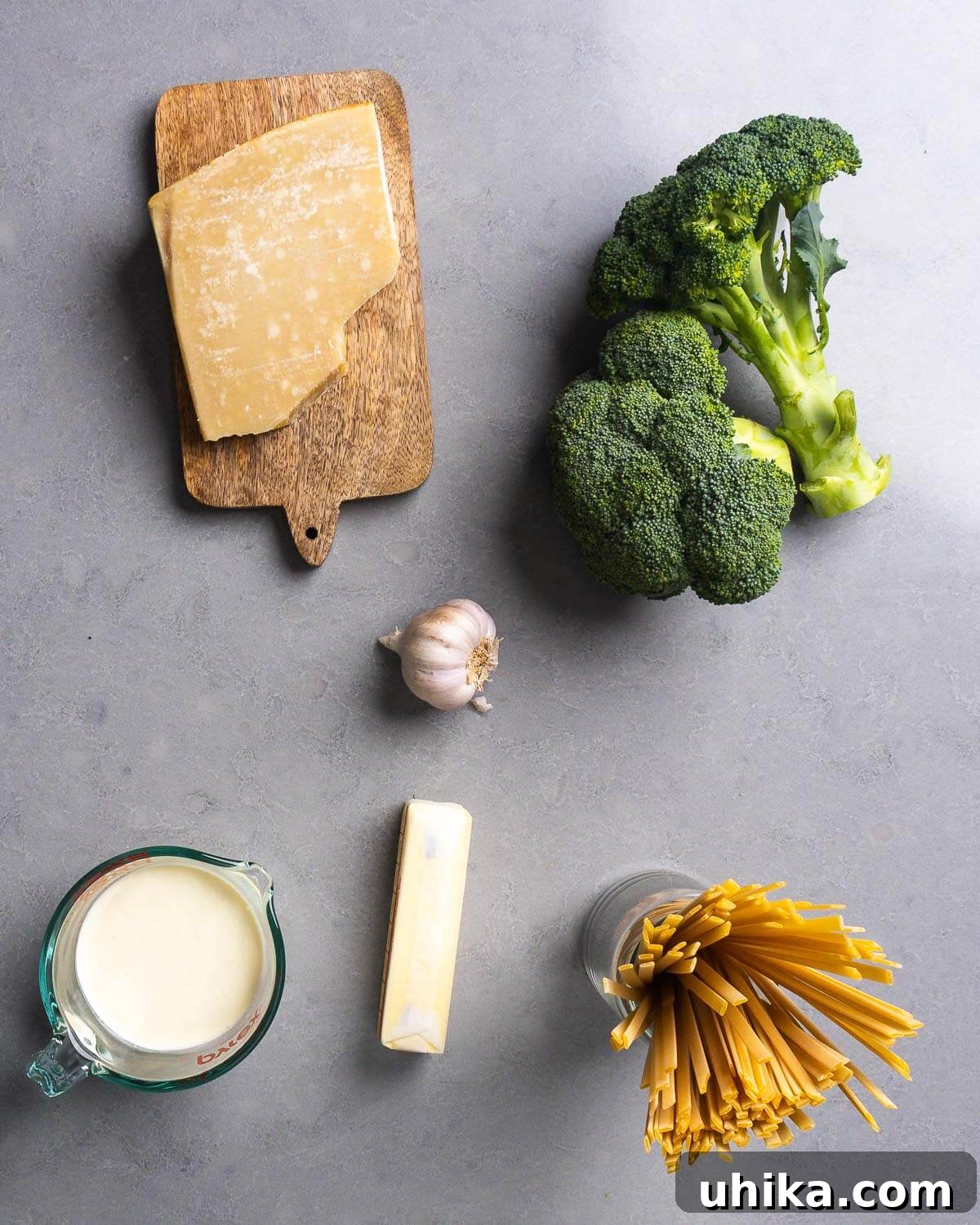 Ingedients shown: block of Parmigiano Reggiano, broccoli, garlic, heavy cream, butter, and fettuccine.